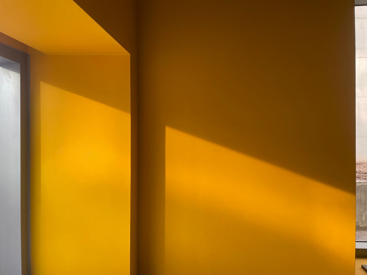 Warm gele muur in een interieur met zonlicht