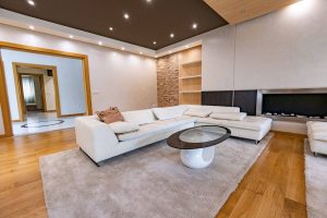 Ruime woonkamer in warme gebroken witte tinten met houten vloer