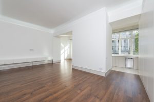 Lege lichte kamer met witte muren en houten vloer