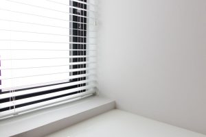 Minimalistisch wit interieur met helderwit raam en lamellen