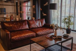 Woonkamer met een bruine leren bank en houten salontafel