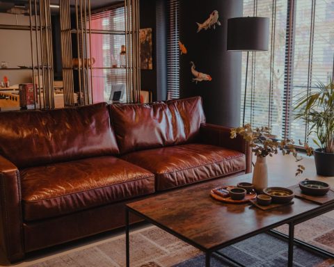 Woonkamer met een bruine leren bank en houten salontafel